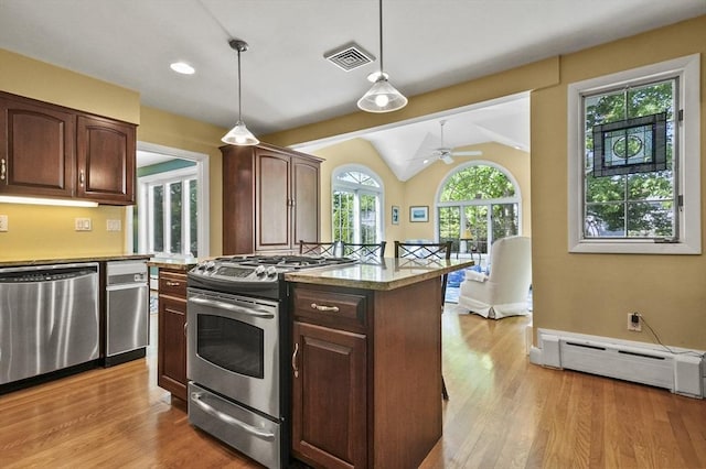 kitchen featuring appliances with stainless steel finishes, a baseboard heating unit, hanging light fixtures, a ceiling fan, and light wood finished floors