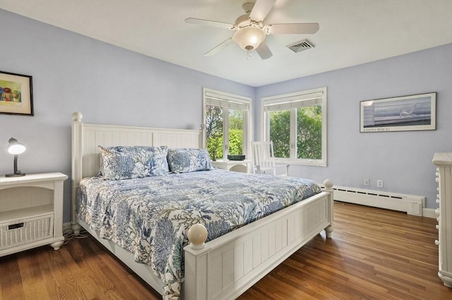 bedroom with baseboard heating, wood finished floors, a ceiling fan, and baseboards