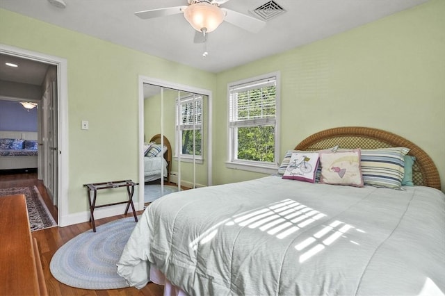 bedroom featuring a closet, wood finished floors, a ceiling fan, and baseboards