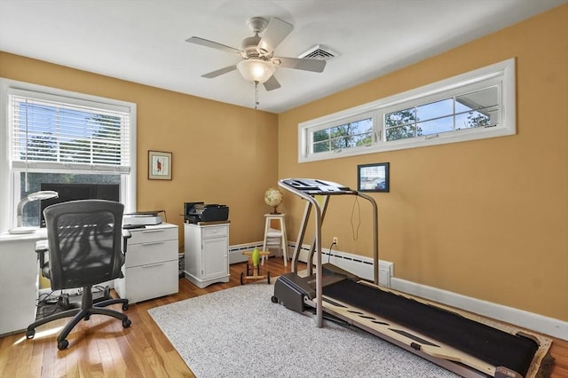 workout area featuring healthy amount of natural light, a ceiling fan, and wood finished floors