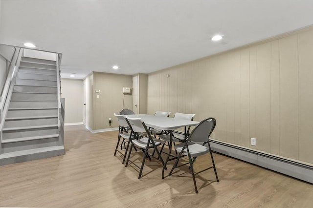 dining space featuring a baseboard heating unit, light wood-style floors, stairway, baseboards, and recessed lighting