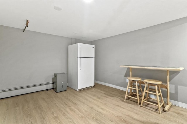 dining space featuring light wood finished floors and baseboards