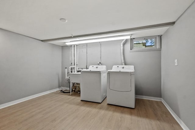 washroom with washer and dryer, light wood-style flooring, and baseboards