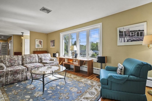 living room with wood finished floors and a baseboard radiator