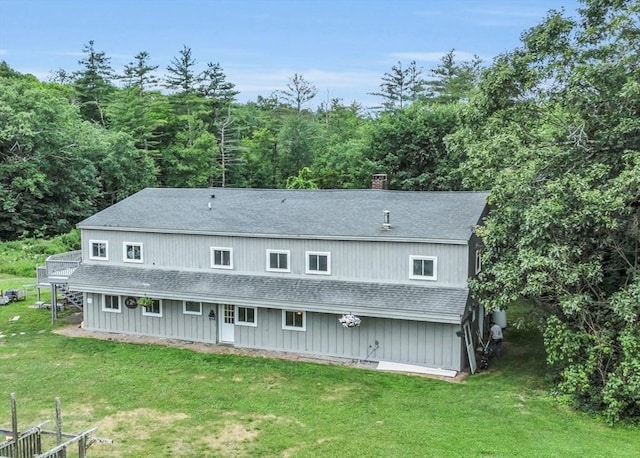 rear view of property featuring a lawn