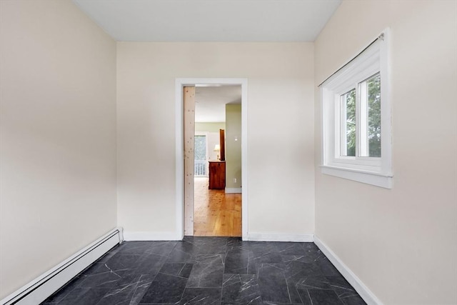 unfurnished room featuring baseboard heating