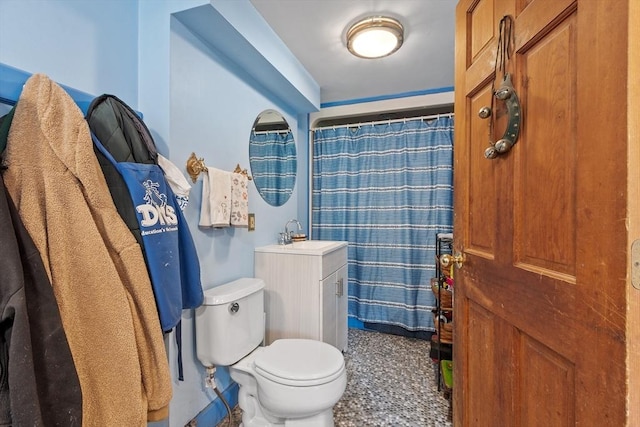 bathroom featuring toilet, vanity, and a shower with shower curtain