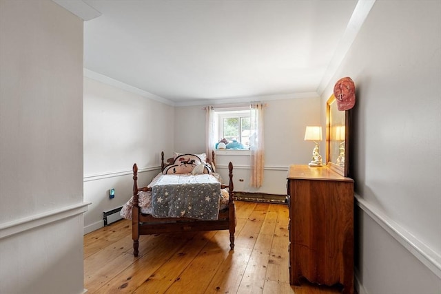 bedroom featuring baseboard heating, ornamental molding, and light hardwood / wood-style floors