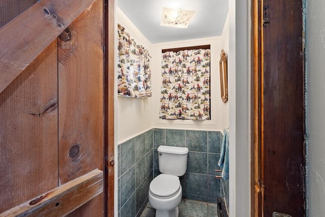 bathroom with tile walls, toilet, and tile patterned flooring