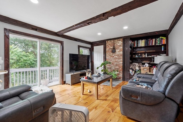 living room with beamed ceiling and light wood-type flooring