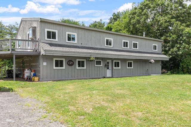 rear view of property with a wooden deck and a yard