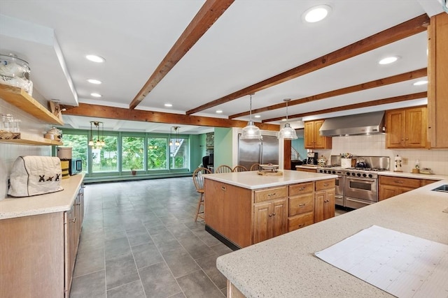 kitchen with premium appliances, decorative light fixtures, wall chimney exhaust hood, a large island with sink, and beamed ceiling