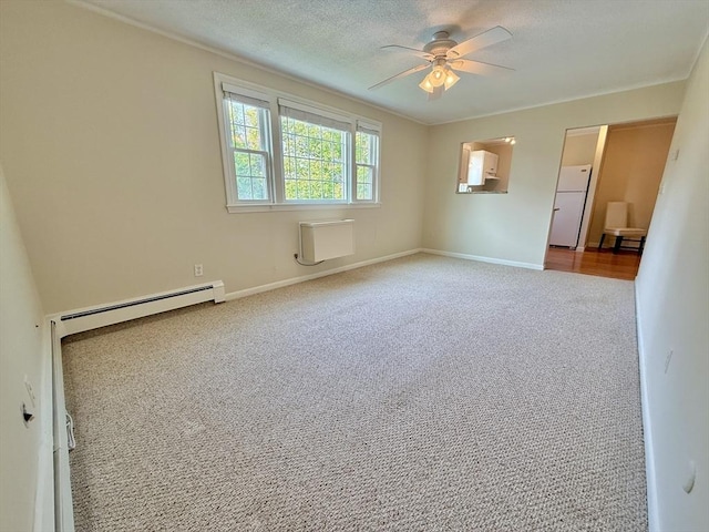 174 Upper County Unit 2-15, Dennis, MA 02639 - carpeted spare room featuring ceiling fan, a baseboard radiator, baseboards, and a textured ceiling