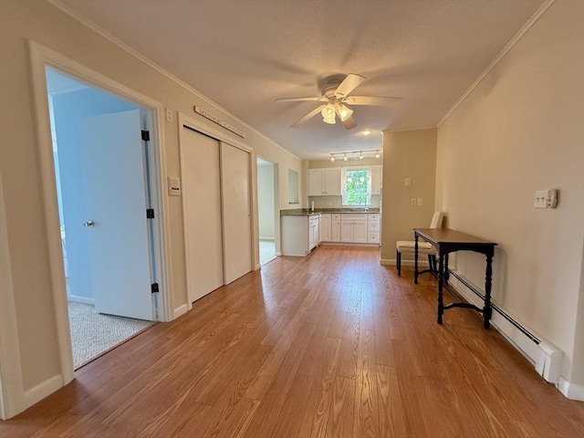 174 Upper County Unit 2-15, Dennis, MA 02639 - unfurnished living room featuring light wood-type flooring, crown molding, a ceiling fan, baseboards, and a sink