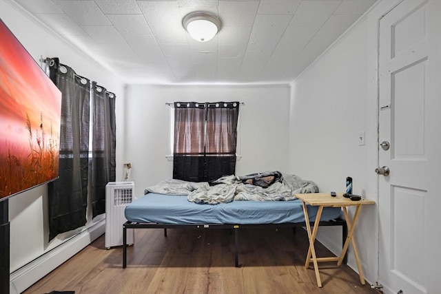 19-21 Pleasant Ter, Lawrence, MA 01841 - bedroom featuring baseboard heating, wood finished floors, and radiator heating unit