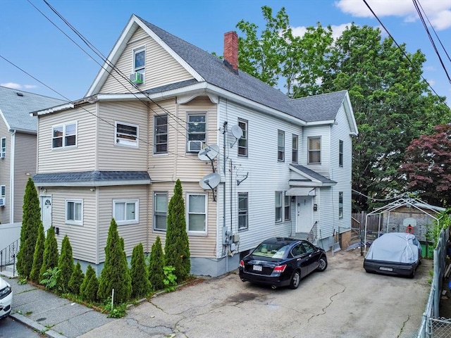 19-21 Pleasant Ter, Lawrence, MA 01841 - view of property featuring a chimney, roof with shingles, and cooling unit