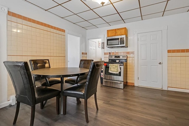 19-21 Pleasant Ter, Lawrence, MA 01841 - dining area featuring tile walls, dark wood-style flooring, and a drop ceiling