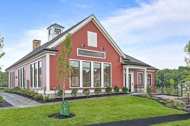 view of front of house with a chimney and a front lawn