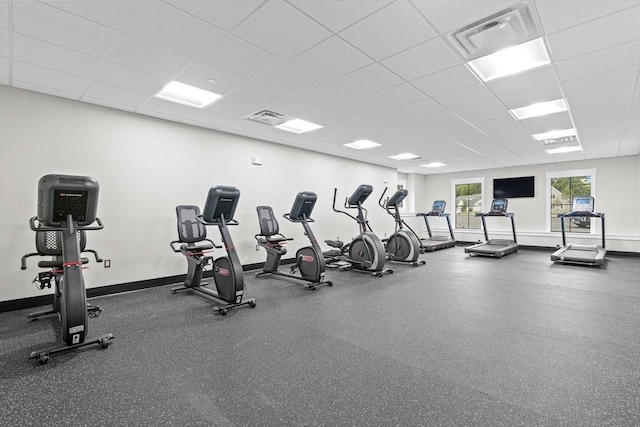 workout area featuring a paneled ceiling, visible vents, and baseboards