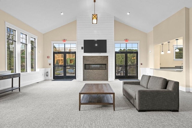 living room with high vaulted ceiling, a large fireplace, carpet flooring, and baseboards