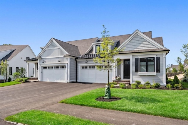 view of front of house with a garage, aphalt driveway, metal roof, a standing seam roof, and a front lawn