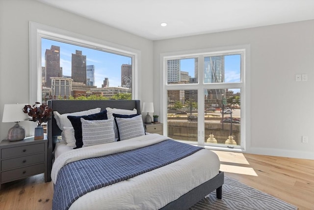 43 Stillman St Unit 201, Boston, MA 02113 - bedroom featuring baseboards, a city view, and wood finished floors