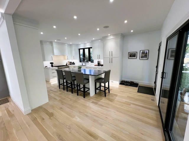 dining space with light wood-type flooring and sink