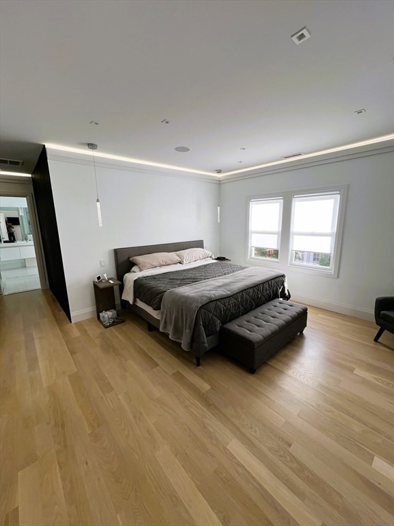 bedroom featuring light hardwood / wood-style floors and crown molding