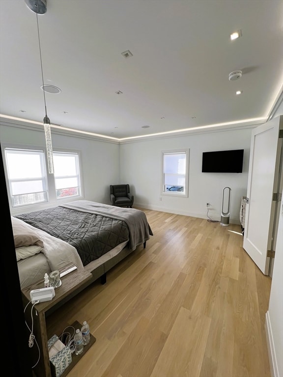 bedroom with light hardwood / wood-style floors and ornamental molding