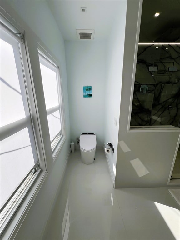 bathroom with walk in shower and toilet