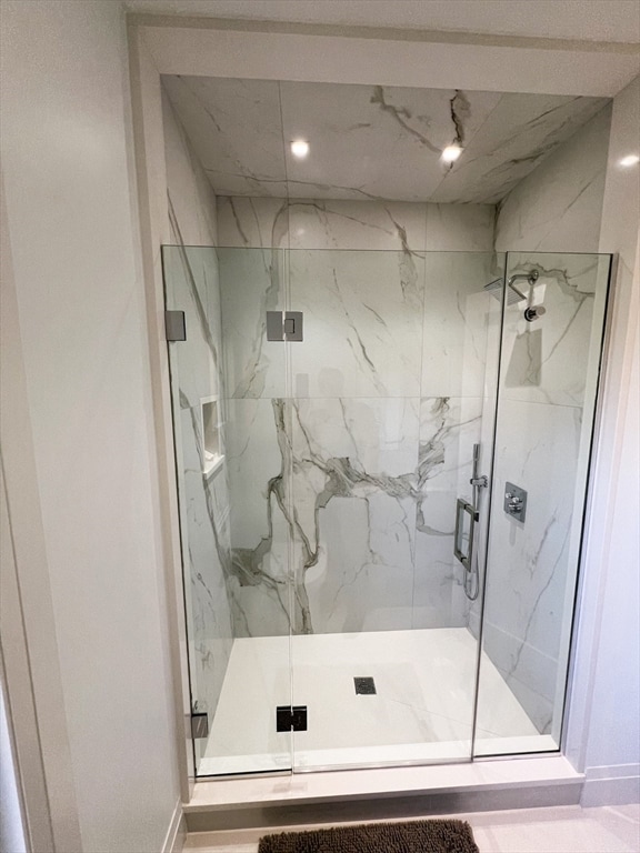 bathroom featuring a shower with door