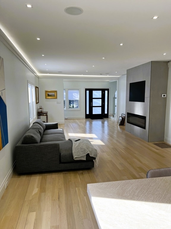 living room with light hardwood / wood-style flooring and a tile fireplace