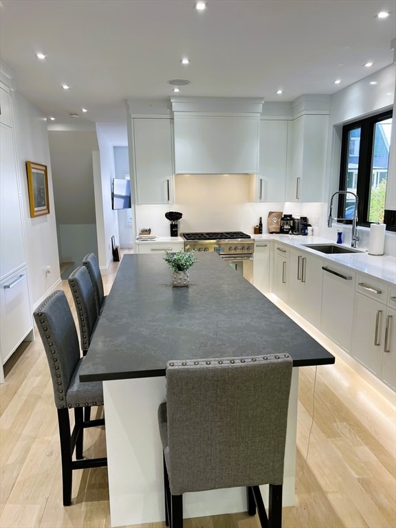 kitchen with a kitchen bar, white cabinets, and a center island