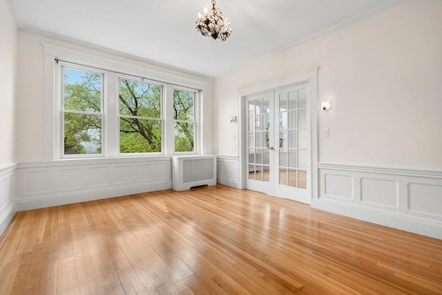 interior space featuring ornamental molding, a wealth of natural light, light wood-style flooring, and radiator heating unit