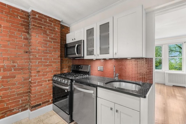kitchen featuring a sink, stainless steel appliances, radiator, and white cabinets