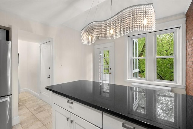 kitchen featuring freestanding refrigerator, a chandelier, light tile patterned floors, white cabinets, and dark countertops