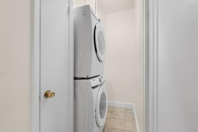 laundry area featuring baseboards and stacked washer and dryer