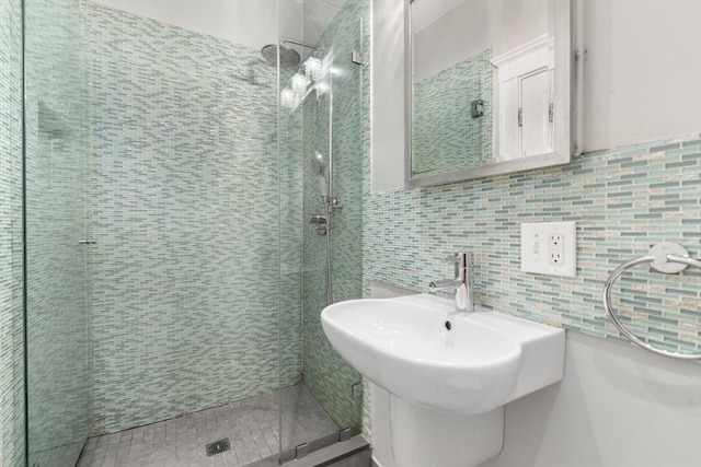full bathroom with a stall shower, tile walls, and backsplash