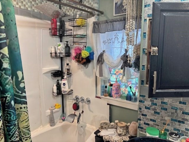 full bath featuring shower / tub combo and decorative backsplash