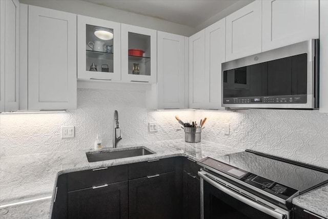 kitchen featuring a sink, appliances with stainless steel finishes, white cabinets, and dark cabinets