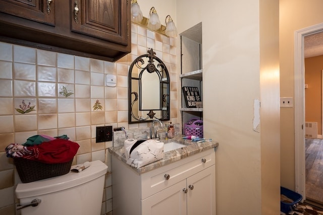 bathroom with toilet, vanity, wood-type flooring, and backsplash