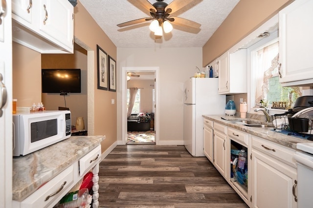 kitchen featuring dark hardwood / wood-style floors, sink, white appliances, and white cabinetry