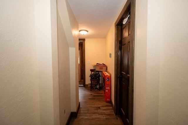 hallway featuring a textured ceiling and dark wood-type flooring