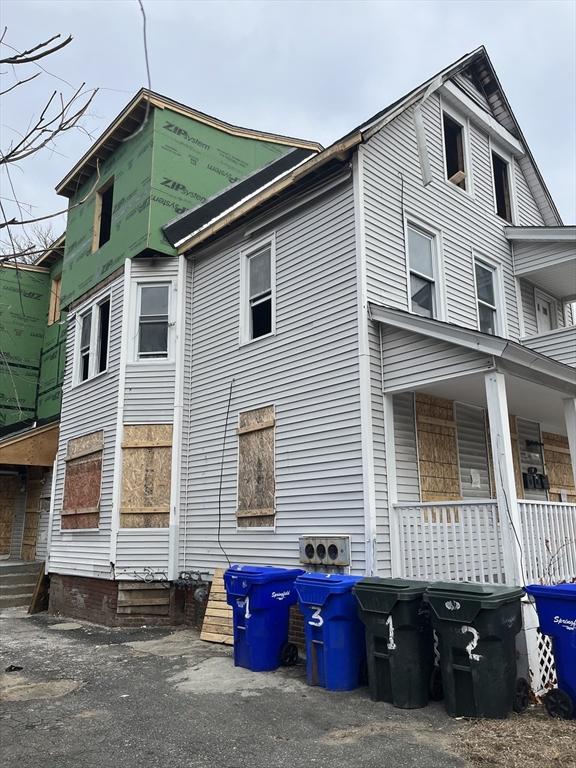 view of side of home featuring covered porch