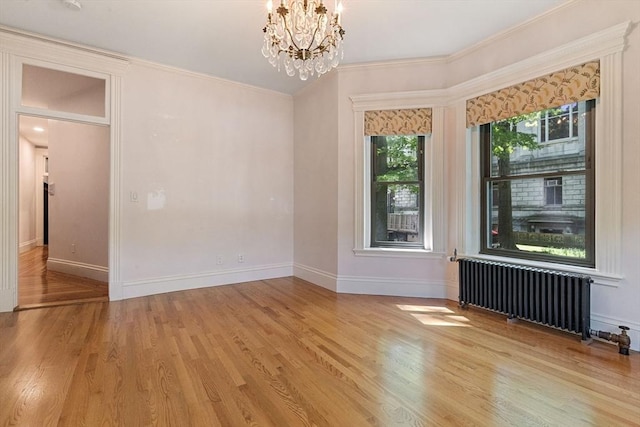 114 Fenway Unit 2, Boston, MA 02115 - spare room featuring radiator heating unit, a chandelier, light wood-style flooring, baseboards, and crown molding