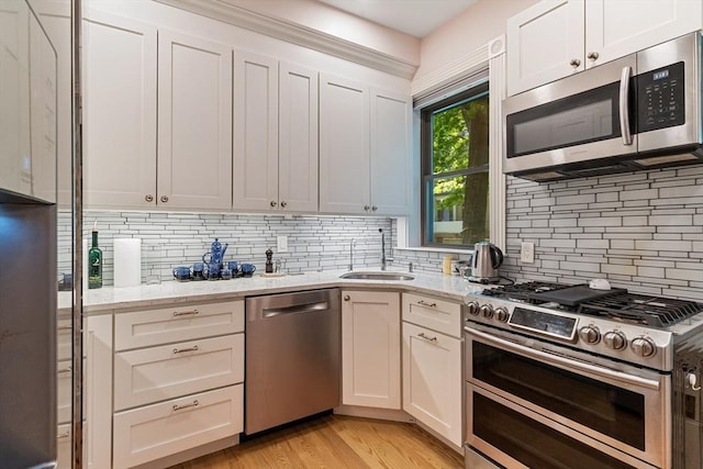 114 Fenway Unit 2, Boston, MA 02115 - kitchen featuring appliances with stainless steel finishes, a sink, decorative backsplash, and light stone countertops
