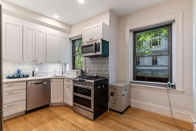 114 Fenway Unit 2, Boston, MA 02115 - kitchen featuring stainless steel appliances, a sink, light countertops, light wood-style floors, and tasteful backsplash