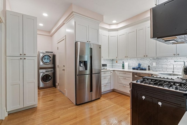 114 Fenway Unit 2, Boston, MA 02115 - kitchen with stainless steel appliances, estacked washer and dryer, extractor fan, light wood-style flooring, and recessed lighting
