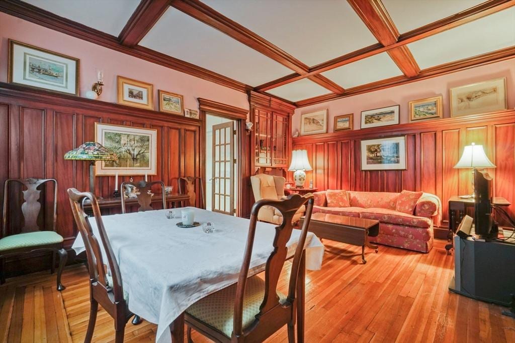 dining area with coffered ceiling, light wood-type flooring, beam ceiling, and french doors