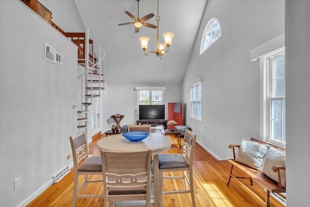 57 Center St, Dartmouth, MA 02748 - dining room featuring light wood-style flooring, high vaulted ceiling, stairs, a ceiling fan, and baseboards
